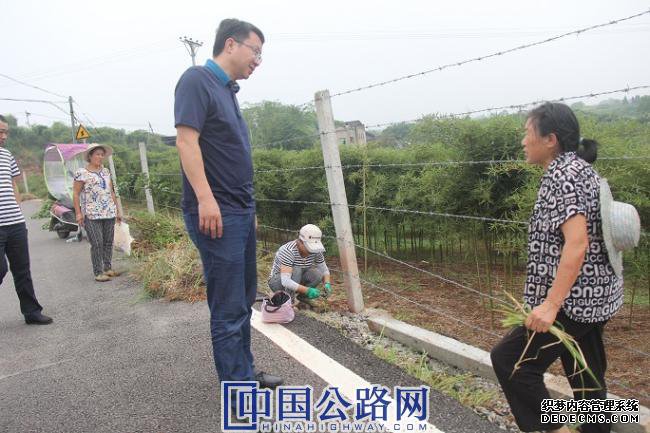 1568509655803795.jpg 9月13日,大足区党委书记、局长覃伦富(左)在车铺村中农竹笋基地与清除路边杂草的村民交谈。蒋文友 摄影.JPG