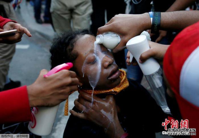 当地时间5月31日,美国华盛顿白宫附近的拉斐特公园的抗议活动中,抗议者们为受胡椒喷雾剂影响的妇女清洗眼部。 当地时间5月31日,美国华盛顿白宫附近的拉斐特公园的抗议活动中,抗议者们为受胡椒喷雾剂影响的妇女清洗眼部。